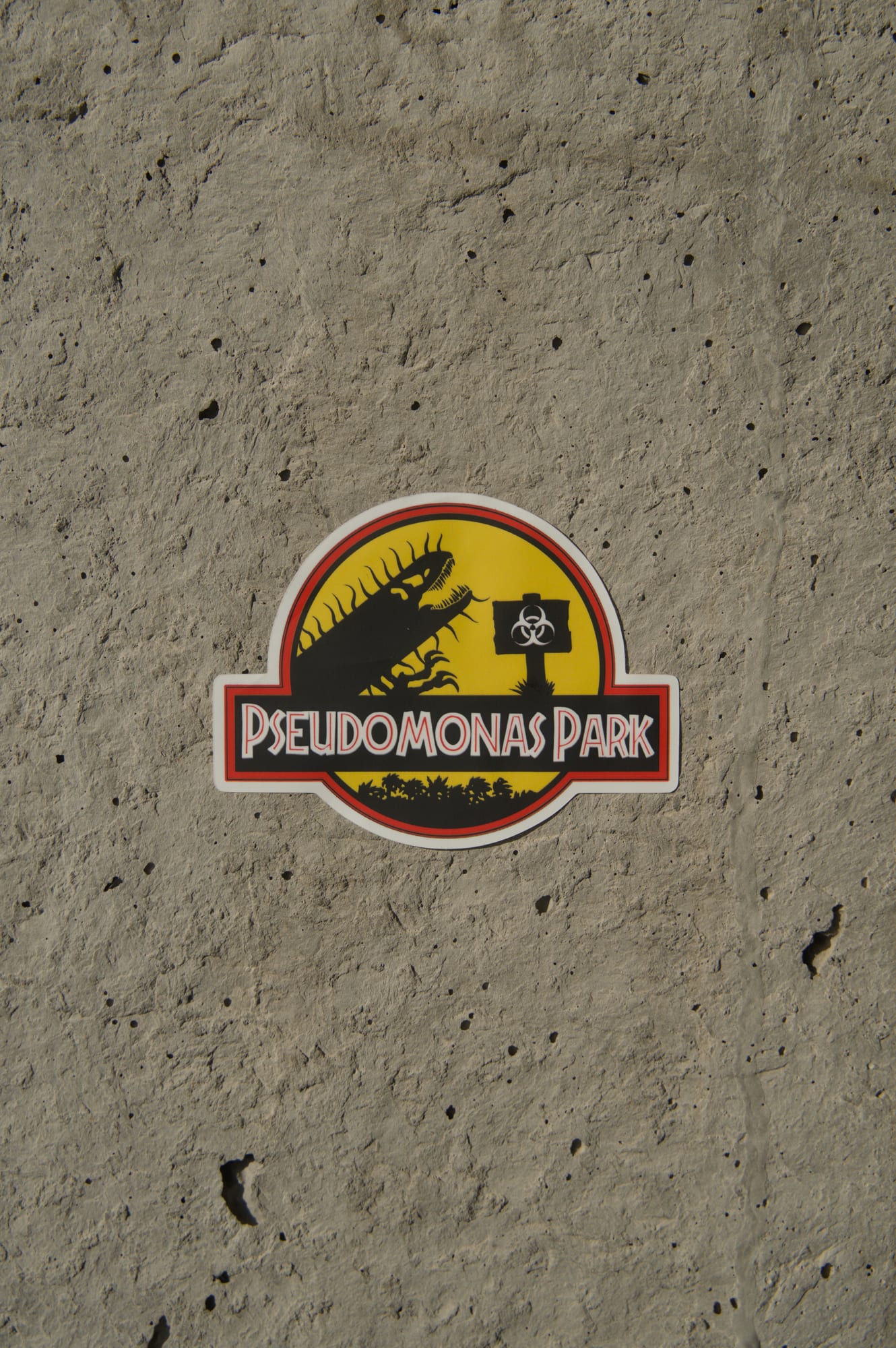Pseudomonas Park sticker on an exposed concrete wall.
